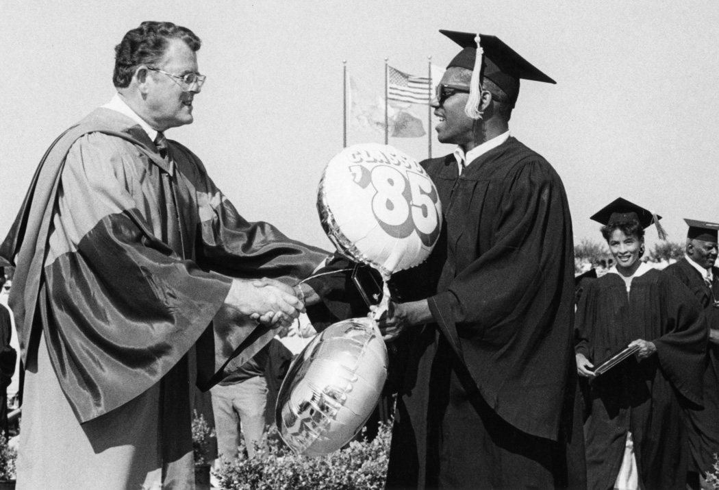 University President Richard Butwell congratulates graduate, 1985